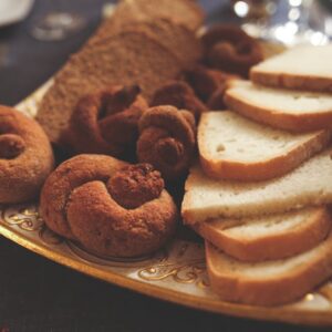 A variety of breads and pastries elegantly arranged on a decorative plate.